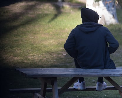 Un menor tutelado sentado en un banco de un parque de Madrid, en 2022.