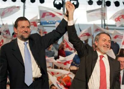 Mariano Rajoy y Jaime Mayor Oreja saludan a sus seguidores en el mitin de fin de campaña.