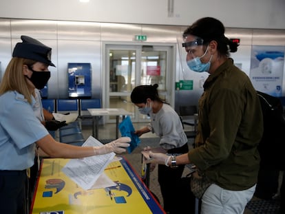 Polícia grega verifica os documentos dos passageiros que chegaram de Doha, no Aeroporto Internacional de Atenas, em 15 de junho.