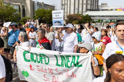 Varias personas, una de ellas con una bandera palestina, sostienen una pancarta durante la concentración de los trabajadores del Hospital Universitario de La Paz, este martes, en Madrid.