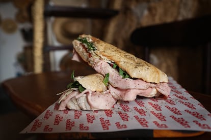 Bocadillo de prosciutto coto a las hierbas mediterráneas, queso de cabra, berenjena asada y rúcula.