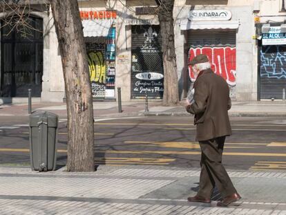 Un hombre pasa frente a multitud de comercios cerrados en Madrid.