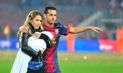 Carolina Martín, con su primer hijo en brazos, y Pedro, en el césped del Camp Nou después de que el Barça se proclamara campeón de la Liga en 2013.
