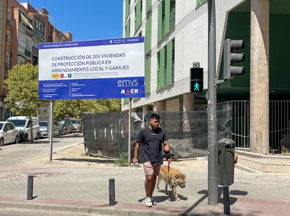 Un hombre pasea con su perro frente a una construcción de vivienda de protección pública, el pasado 9 de julio en el distrito de Puente de Vallecas, en Madrid.