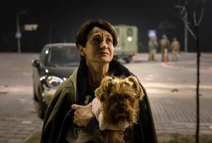 Una residente, con su perro en brazos, sale de su apartamento después de que el edificio fuera alcanzado por los restos de un cohete derribado en Kiev, el 20 de marzo. Miles de personas han perdido sus casas debido a la intensificación de la violencia según avanza el conflicto.