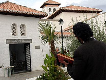 Un musulman en el jardín de la mezquita Mayor de Granada con un Corán en las manos.