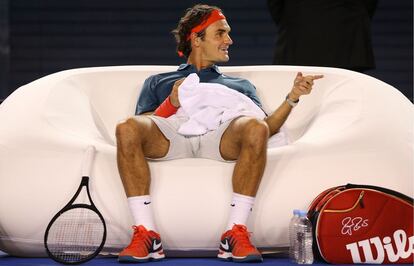 El tenista suizo Roger Federer descansando entre juegos en un sofá, durante su partido de exhibición ante el francés Jo Wilfried Tsonga en un torneo de caridad patrocinado por él mismo en Melbourne, Australia.