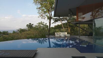 El arquitecto Víctor Cañas firmó esta
casa-mirador sujeta sobre 13 ligeros pilares
y con un forjado atravesado por algunos árboles. Frente a la piscina desbordante,
los sofás del mobiliario exterior son de La-fete
y las tumbonas
de Altea Design.