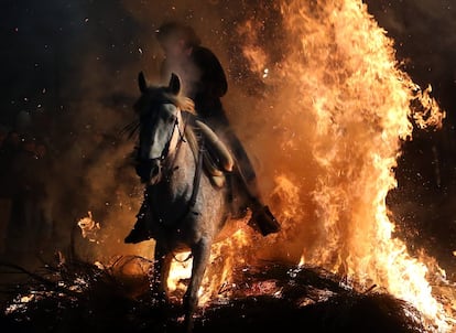 Desde hace más de dos siglos, los vecinos de este pueblo purifican a los equinos por medio del fuego y del humo de las grandes hogueras repartidas en las calles de esta localidad de 581 habitantes. Estos creen que de esta manera ahuyentan a los malos espíritus y protegen a los animales de las epidemias. En la imagen, un jinete con su caballo durante el salto en una de las hogueras.