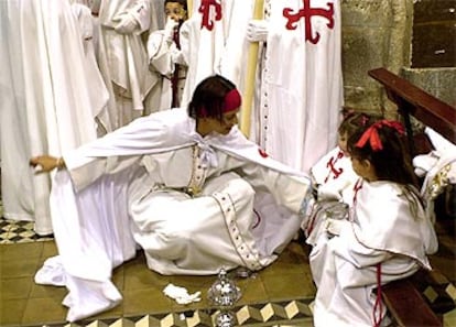 Varios jóvenes nazarenos se preparan para la procesión del Lignum Crucis y la Piedad que han recorrido las calles de la ciudad de La Laguna (Tenerife).