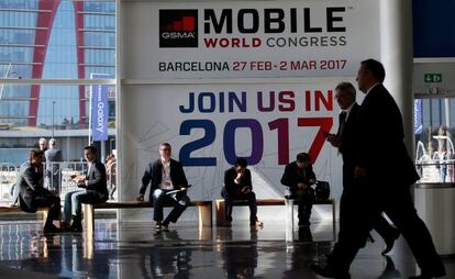 Assistents de l'última edició del MWC amb un cartell que els animava a assistir a la fira d'aquest any.