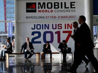 Assistents de l'última edició del MWC amb un cartell que els animava a assistir a la fira d'aquest any.