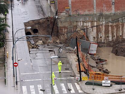 La calle del Doctor Ferran, en Alzira, con el socavón provocado por la mala cimentación de las obras del solar de la derecha.