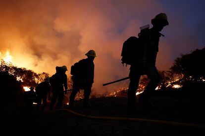 Un grupo de bomberos camina durante las operaciones realizadas para frenar la propagación del incendio de Caldor en Grizzly Flats, California, EE UU.