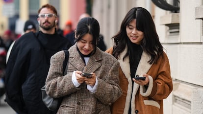 A guest wears an oversized blazer beige jacket, purple pants, outside K-WAY