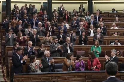 Socialist deputies applaud the finance minister during the budget debate.