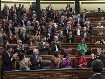 Socialist deputies applaud the finance minister during the budget debate.