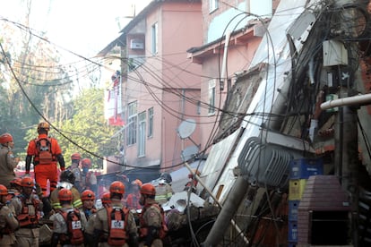 Bombeiros buscam vítimas entre os escombros do edifício que desabou na madrugada de desta quinta-feira na comunidade de Rio das Pedras, no Rio.