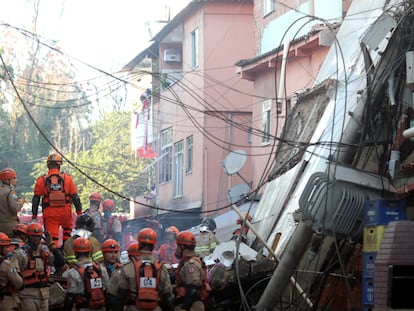 Bombeiros buscam vítimas entre os escombros do edifício que desabou na madrugada de desta quinta-feira na comunidade de Rio das Pedras, no Rio.