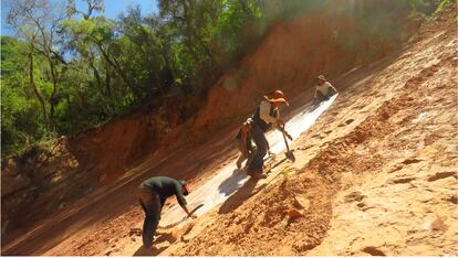 Geologist Gustavo Méndez Torres, who discovered the footprints, works with biology students on the slope that contains several levels with dinosaur footprints. 