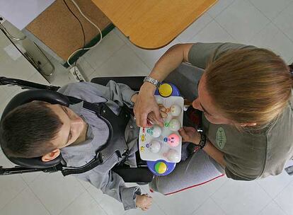 Un afectado por parálisis cerebral es atendido en el colegio de educación especial Numen, en Madrid.