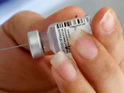 A healthcare worker prepares a dose of COVID-19 vaccine at Maccabi 