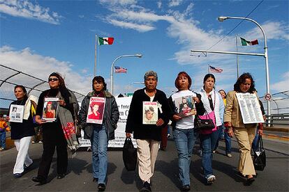 Familiares y amigos de las mujeres asesinadas en Ciudad Juárez llevan sus fotos en una manifestación.