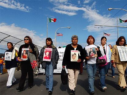 Familiares y amigos de las mujeres asesinadas en Ciudad Juárez llevan sus fotos en una manifestación.