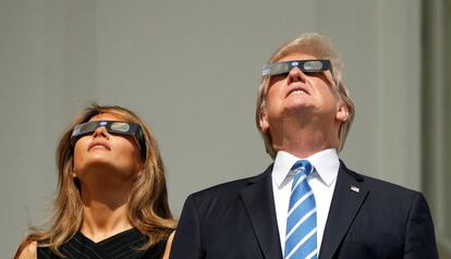 Melania y Donald Trump observan el eclipse de sol, en el balcón de la Casa Blanca.