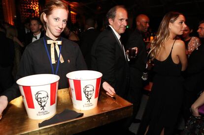 Una camarera sirve alitas de pollo de la compañía Kentucky Fried Chicken durante una fiesta posterior a la gala de los Globos de Oro celebrada en Los Ángeles en 2016.