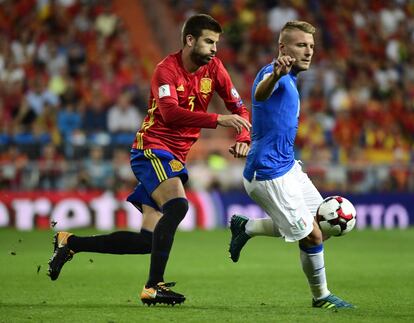 El defensa español Gerard Pique compite con el delantero italiano Ciro Immobile.