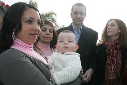 Melisa Matamoros con Carmen en brazos. Al fondo, Antonio Ponce, en el hospital Virgen del Rocío.