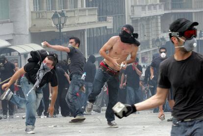 Unos manifestantes lanzan adoquines a las puertas del Parlamento, en Atenas, el miércoles.