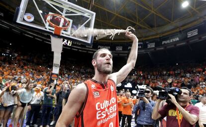 El jugador francés del Valencia Basket, Antoine Diot, tras cortar la red de una de las canastas, celebra el título de campeones de la Liga ACB tras imponerse en el cuarto partido al Real Madrid esta noche en el pabellón de la Fuente de San Luis de Valencia.