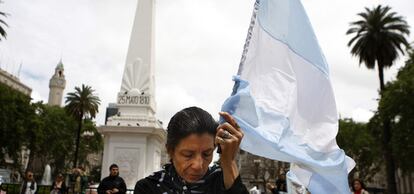 Una mujer, que sostiene una bandera de Argentina, muestra su pesar por la muerte de Néstor Kirchner frente a la Casa Rosada en Buenos Aires.