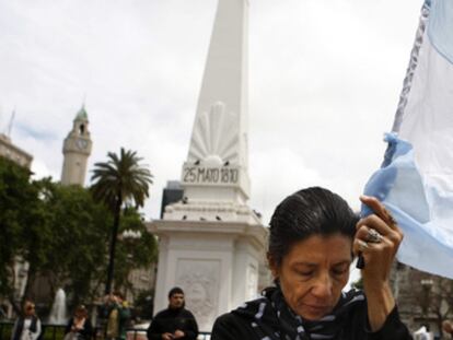 Una mujer, que sostiene una bandera de Argentina, muestra su pesar por la muerte de Néstor Kirchner frente a la Casa Rosada en Buenos Aires.