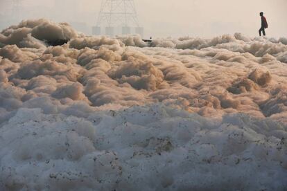 El pasado diciembre un hombre cruza en la India Yamuna, altamente contaminado por residuos tóxicos.