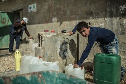 Un niño recoge agua en el campo de Zaatari, en Jordania.