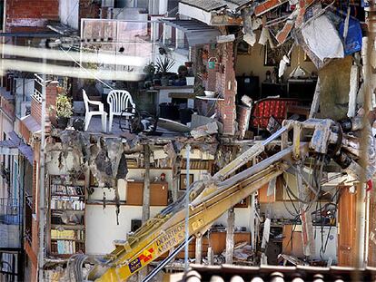 La demolición del edificio número 10 del pasaje Calafell, adjunto al socavón que se tragó un garaje el jueves pasado, puso al descubierto el interior de las viviendas.
