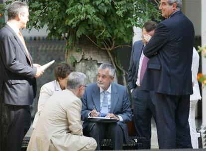 Griñán revisaba ayer documentación con su equipo en el patio del Parlamento de Andalucía.