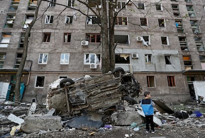 Un niño mira un coche destruido en la ciudad de Mariupol (sudeste). Rusia ha anunciado por primera vez un alto el fuego para abrir un corredor humanitario desde la acería de Azovstal sin pedir a cambio la rendición de los soldados ucranios, aunque las autoridades ucranias no han confirmado que se haya concretado.