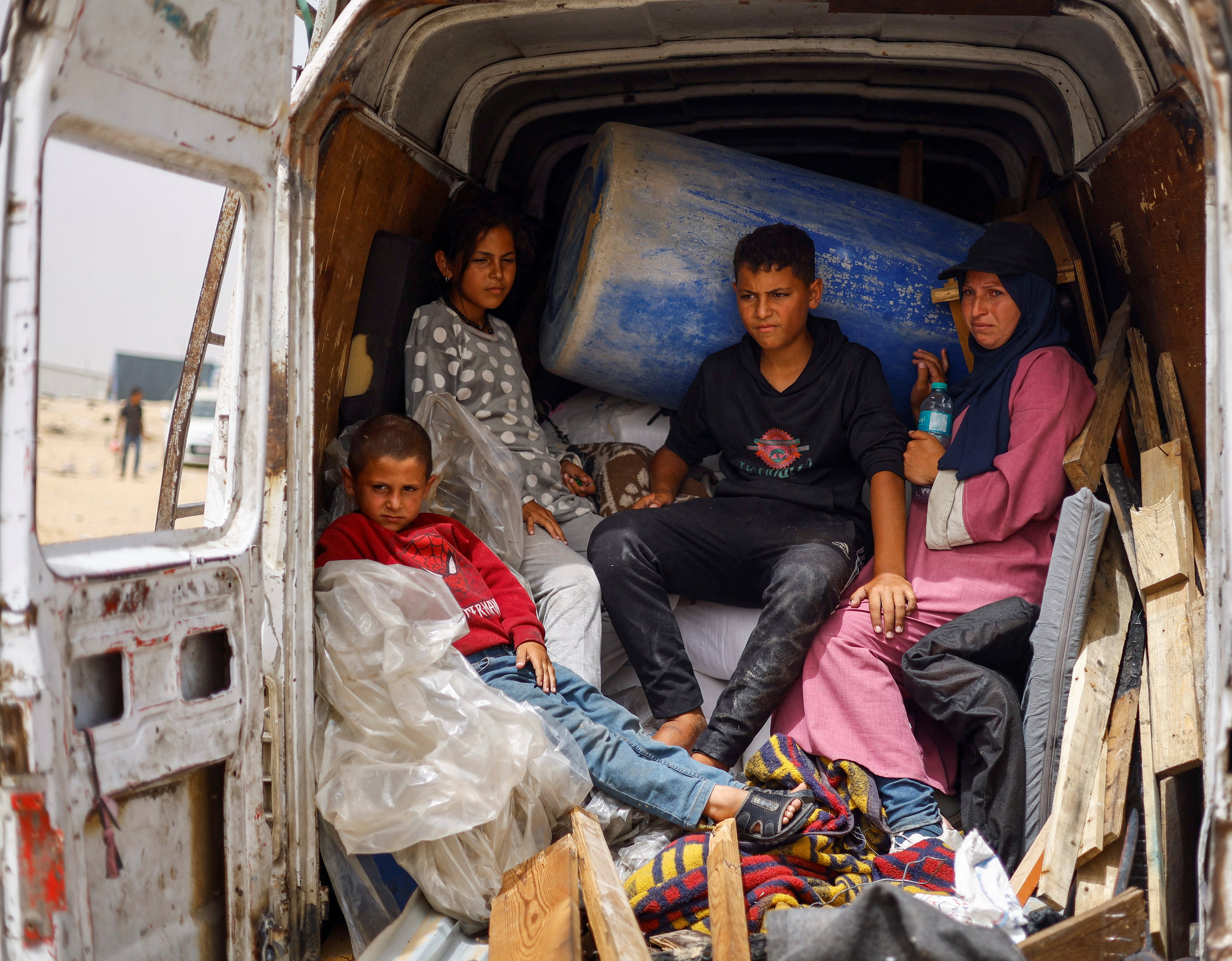 Palestinos desplazados de la familia Salman abandonan Rafah en una furgoneta con sus pertenencias, tras el ataque israelí ocurrido este lunes en el campo de Tal Al-Sultan.