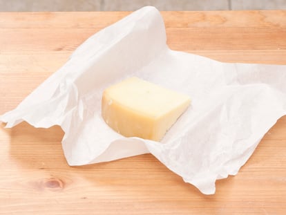 Un trozo de queso envuelto en papel.