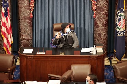 Un manifestante se sienta en lugar de la presidenta de la Cámara.