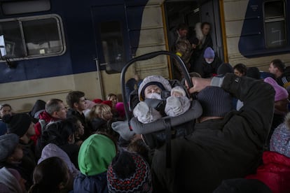 En la imagen, un hombre levantaba a su bebé entre la multitud que trataba de entrar en un tren en la estación de Kiev para huir de la capital, el 4 de marzo. Las tropas del Kremlin no lograron avances significativos en el control de las ciudades ucranias que mantienen sitiadas, cuando se cumple un mes de la invasión.
