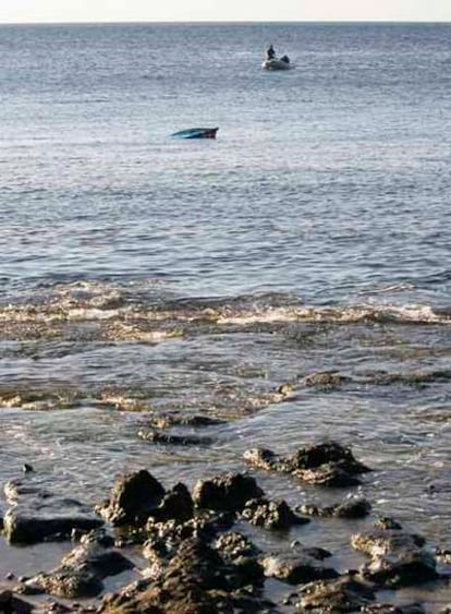 La patera en la que viajaban los inmigrantes, semihundida al lado de la costa de Gran Canaria, tras el naufragio.