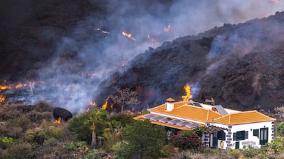 La lava del volcán de La Palma cerca de una vivienda este martes.