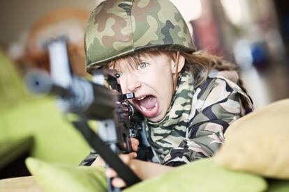 Niña juega en el salón de su casa a ser una soldado.