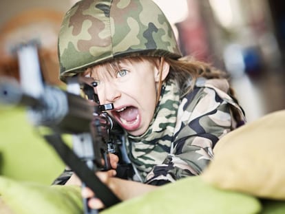 Niña juega en el salón de su casa a ser una soldado.