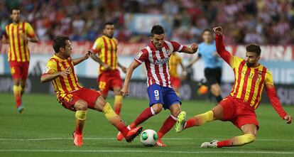 David Villa intenta el disparo, ante la presencia de los defensores Piqué y Jordi Alba.